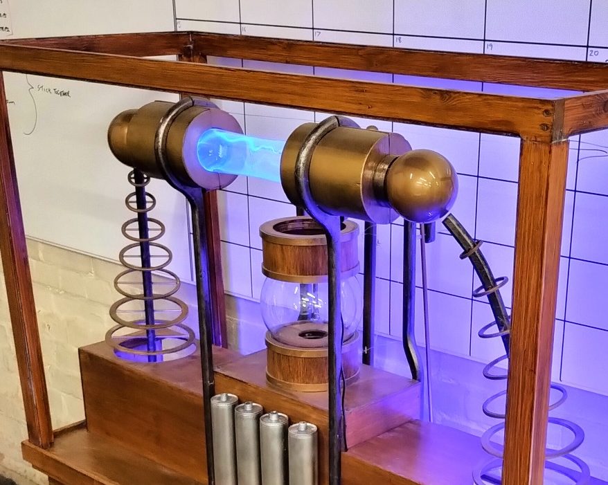 A vintage-style electrical device with glowing components and intricate springs.