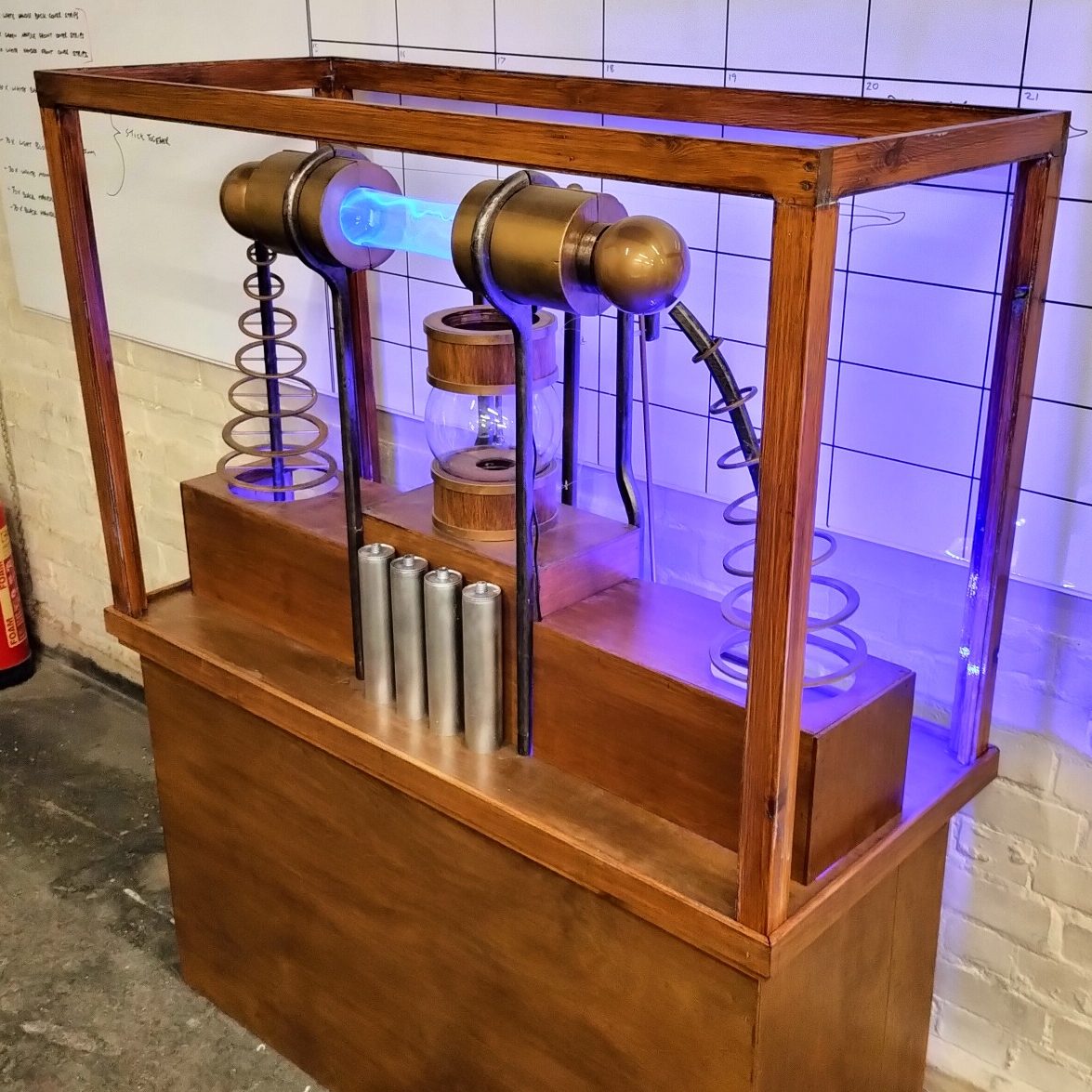 A vintage-style electrical device in a wooden display case with glowing elements.