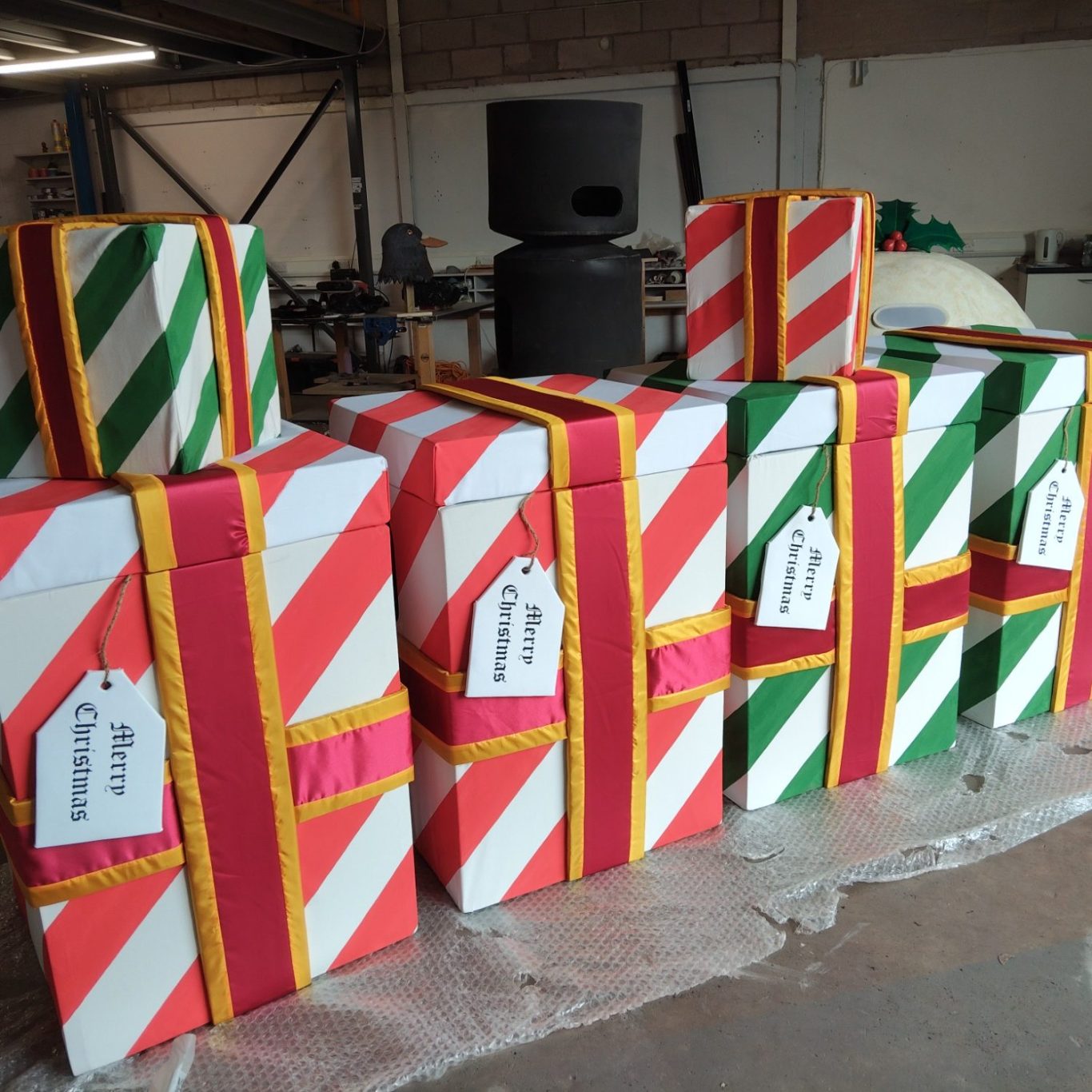 Colourfully wrapped gift boxes with red, green, and white stripes and tags.